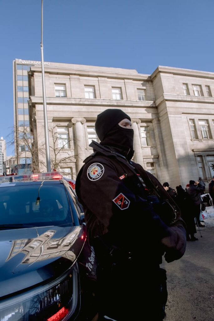 A Police Officer Standing by a Car