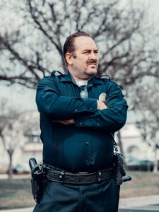 Policeman Standing Near Bare Trees